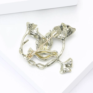 Back view of gold enamel dove brooch showing the pin clasp and textured metal alloy surface