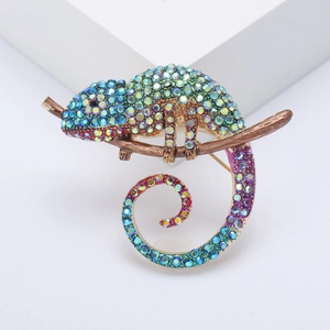 Chameleon brooch with colorful crystals on a gold branch in a detailed macro view