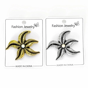 Detailed view of starfish brooches in gold and silver with sparkling center crystals