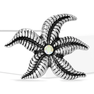 Detail view of vintage silver starfish brooch with engraved texture and shiny rhinestone