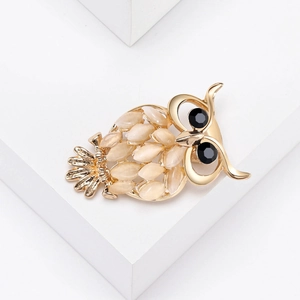 Vue détaillée de la broche hibou avec pierres œil de chat crème et yeux en pierres noires