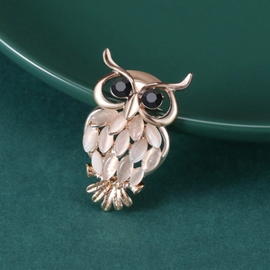 Vue détaillée de la broche hibou avec base en métal doré et abdomen en opale blanche