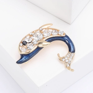 Vue macro d'une broche dauphin en émail bleu et strass brillants sur métal doré