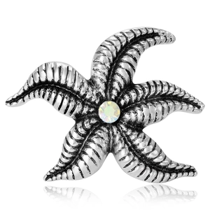 Starfish shaped silver alloy brooch with a colorful rhinestone on white background