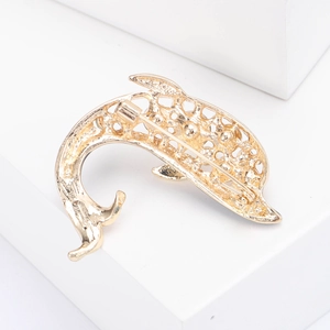 Vue macro du dos d'une broche dauphin plaquée or avec maille creuse et épingle en métal