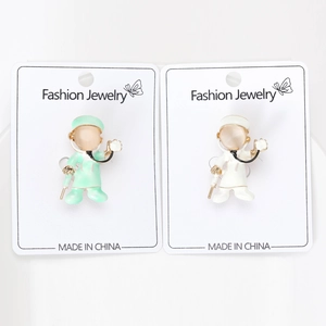 Detail of cartoon doctor brooches with green and white uniforms and stone heads
