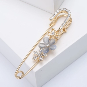 Elegant gold flower safety pin brooch with grey cat eye petals and sparkling rhinestones