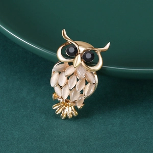 Détail d'une broche chouette avec des pierres œil de chat et des yeux en gemmes noires