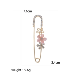 Floral safety pin brooch with pink cat's eye stone and crystals on golden base