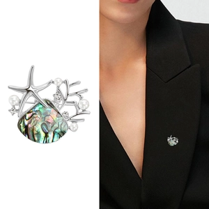 Detailed view of ocean theme brooch with abalone shell, starfish and pearl accents