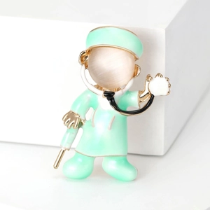 Macro detail of cartoon doctor brooch with mint green enamel and cat eye gemstone