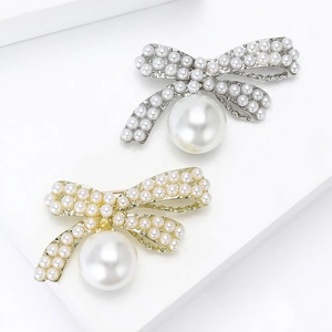 Elegant bow brooch with pearl embellishments in silver and gold metal finishes