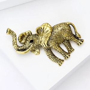 Detailed close-up of a vintage golden elephant brooch with intricate grid textures