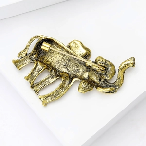 Detailed back view of vintage gold elephant brooch showing pin clasp and hammered metal texture