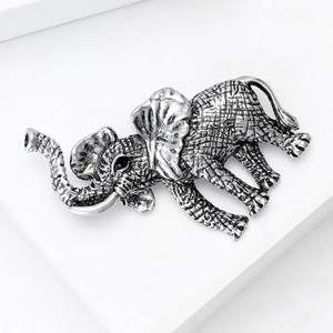 Macro shot of vintage silver elephant brooch with realistic textures and black diamond eyes