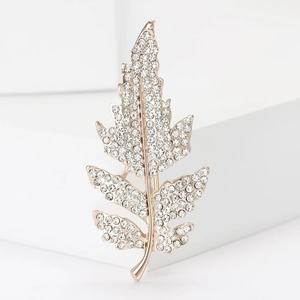 Élégante broche en forme de feuille rose doré avec cristaux sur support blanc