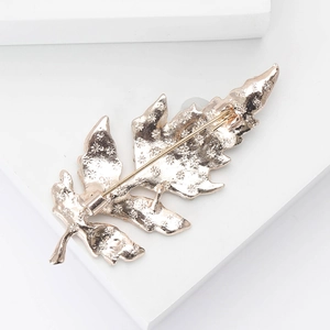 Vue détaillée du dos de la broche feuille avec épingle de sûreté et texture alliage