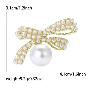 Elegant pearl bow brooch with gold metal base and size dimensions shown on white background