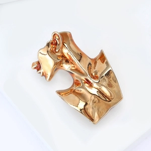 Abstract sculpture brooch in polished gold finish with a minimalist face silhouette design