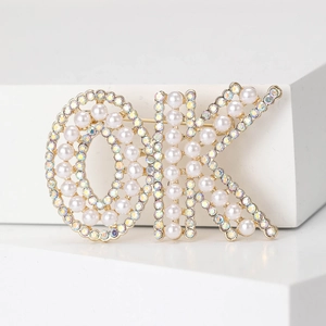 Broche perle en forme de OK avec finition dorée et cristaux pour manteaux