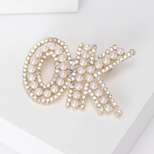 Vue macro d'une broche de luxe avec perles et cristaux en forme de lettre DK