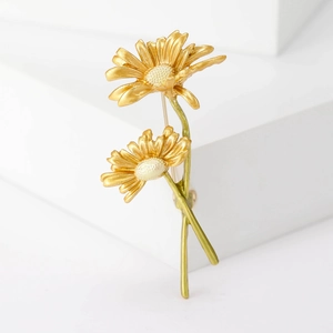 Dettaglio macro della spilla a margherita in smalto fatta a mano con steli e petali d'oro