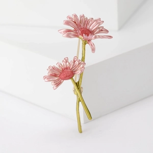 Dettaglio macro della spilla a margherita in smalto fatta a mano con petali rosa su pietra