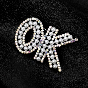 Détail de la broche nœud argentée avec perles et strass sur fond en cuir noir élégant