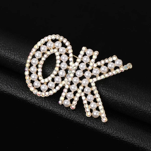 Vue macro d'une broche papillon dorée avec perles blanches et strass AB multicolores