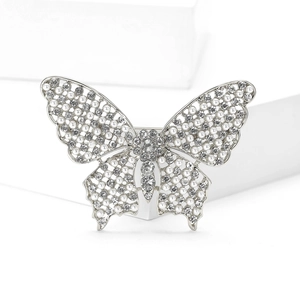 Détail de la broche papillon en argent avec perles et strass sur des ailes en maille