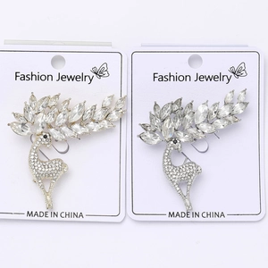 Detailed view of silver and gold reindeer brooches with crystals on display card