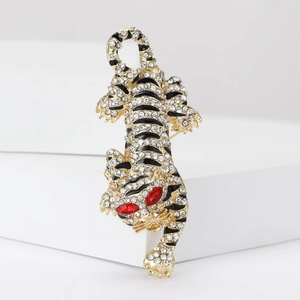 Broche tigre dorée avec strass scintillants et émail noir sur support blanc élégant