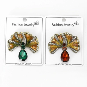 Detail of vintage fan-shaped brooches with colorful gemstones and golden alloy base