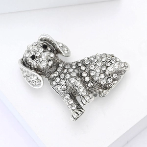 Détails macro de la broche chiot en alliage avec strass étincelants sur socle blanc