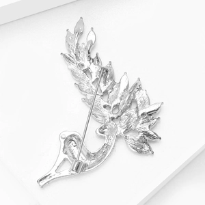 Macro shot of silver deer brooch back showing safety pin and smooth metal texture