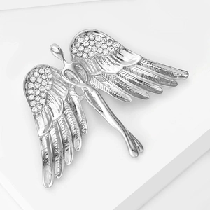 Detailed view of silver angel wing brooch with sparkling white rhinestones on pedestal