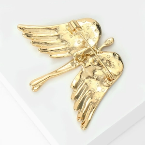 Detailed back view of golden angel wing brooch showing safety pin clasp and star patterns