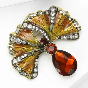 Detailed view of ginkgo leaf brooch with brown enamel, rhinestones and amber drop gem