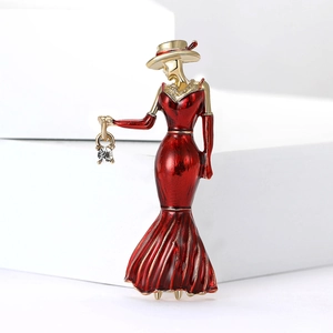 Elegant enamel brooch of a lady in a red gown with wide-brimmed hat and metal base