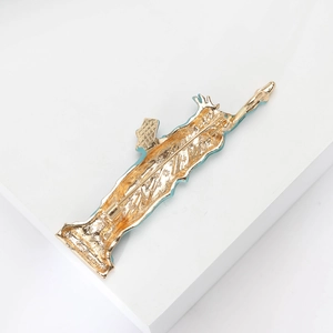 Detailed back view of the Statue of Liberty brooch showing the pin clasp and gold metal texture
