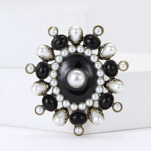 Vintage alloy pearl medal brooch with black resin stones on white geometric stand
