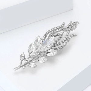Macro shot of peacock feather brooch with sparkling crystals on a minimalist stand