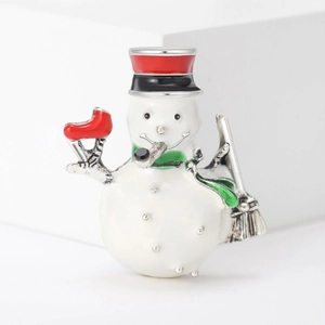 Detailaufnahme einer Schneemann-Emaille-Brosche mit rotem Hut und grünem Schal auf Weiß