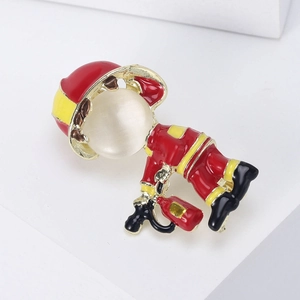 Close-up of creative firefighter brooch with red enamel and a cat eye stone head detail