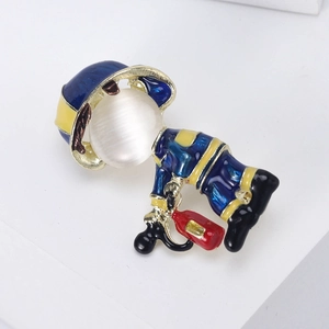 Macro shot of cute firefighter brooch with cat eye stone head and colorful enamel coat