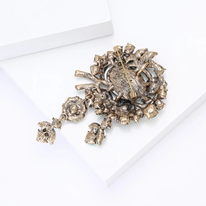 Detailed back view of vintage gold alloy brooch with metal pin clasp and green stone
