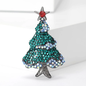 Macro detail of Christmas tree brooch featuring green rhinestones and silver star on metal