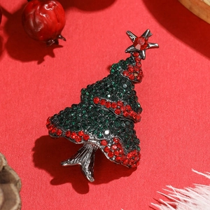 Detailed close-up of a sparkling Christmas tree brooch with green and red rhinestones