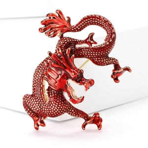 Macro shot of a red enamel Chinese dragon brooch with textured gold alloy detailing