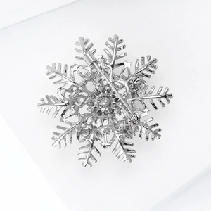 Detailed back view of silver snowflake brooch showing safety pin clasp and hollow pattern